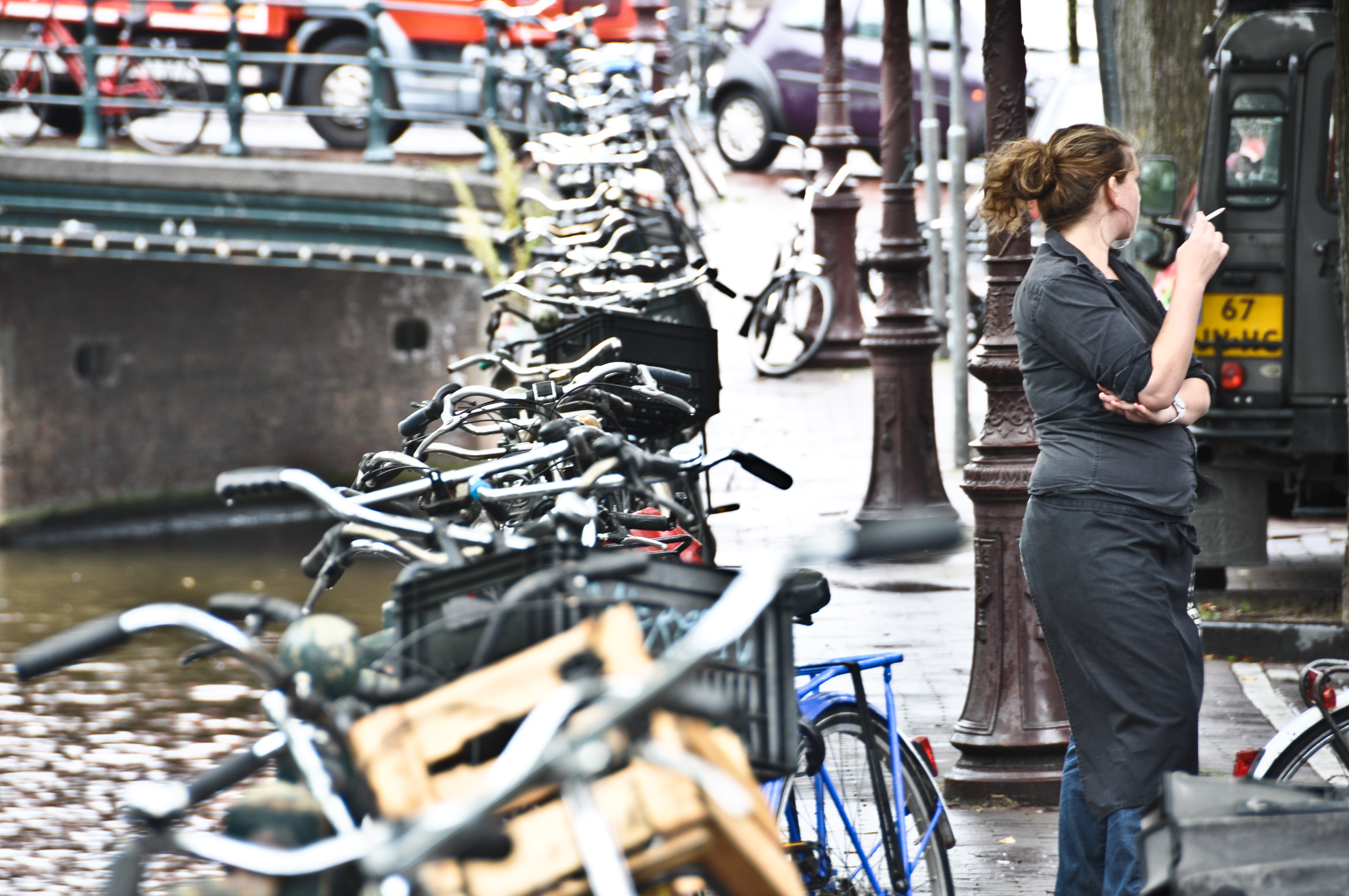 woman smoking with row of bikes