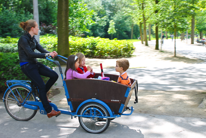 Young girl transporting children in the cart . Amsterdam. Nether