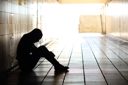 Teenager depressed sitting inside a dirty tunnel