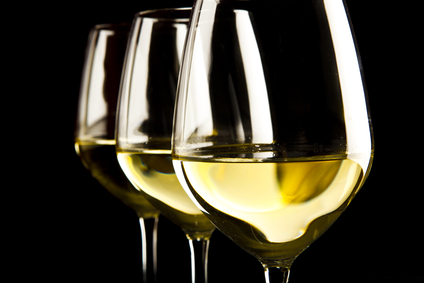 three glasses of white wine on black background