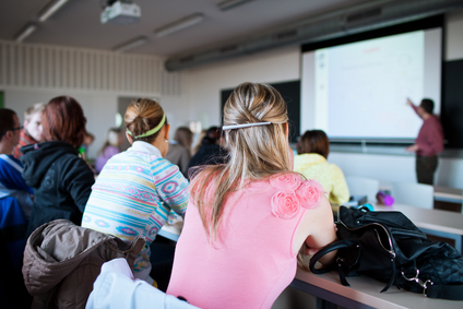 young, pretty female college student sitting in a classroom full