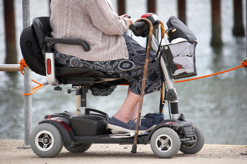 Senior woman at the seaside on mobility scooter