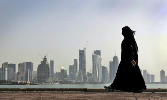 A Qatari woman walks in front of the city skyline in Doha. Photo: AP/Kamran Jebreili