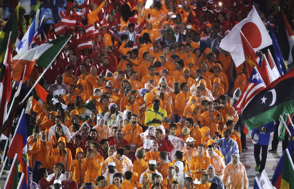 Spot the medalist. TeamNL in the rain during the Olympics closing ceremony. AP Photo/Charlie Riedel)