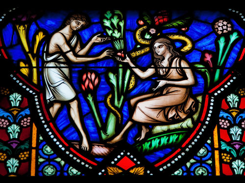 Stained glass window featuring Adam, Eve and an apple. Photo: Deposit Photos.