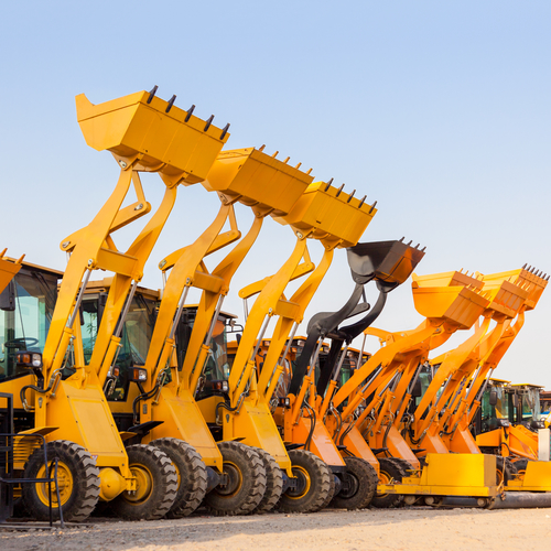 Row of heavy construction excavator machine  against blue sky in a construction site.