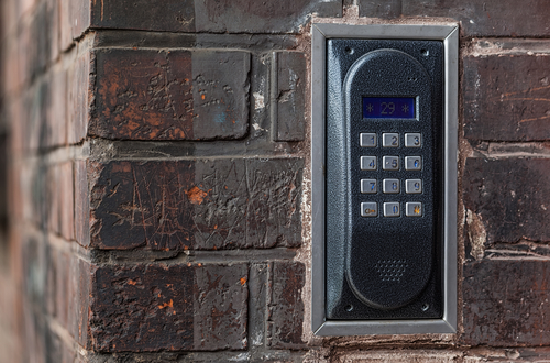 Old intercom on a red brick wall