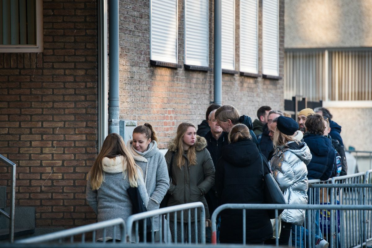 People queuing outside the high-security courthouse De Bunker to watch Astrid Holleeder give testimony against her brother Willem during his trial for murder and manslaughter.