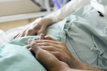 一名护士和病人在医院里接触双手。