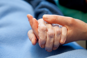 Young person holding old person's hand.