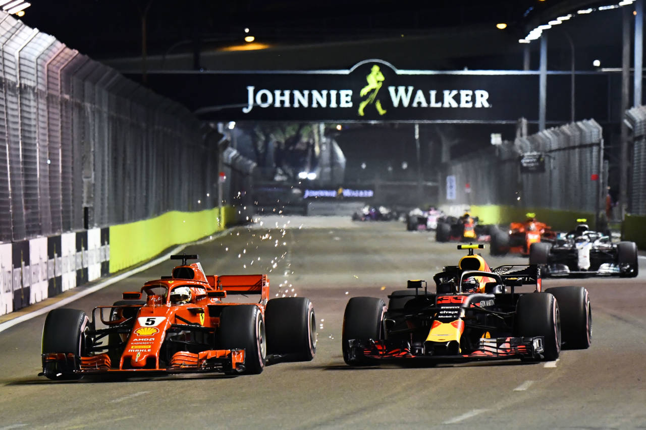 Sebastian Vettel's Ferrari overtaking Max Verstappen in a Red Bull on the opening lap of the Singapore Grand Prix.