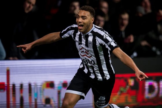 Cyriel Dessers of Heracles spreads his arms to celebrate scoring the winning goal against Ajax