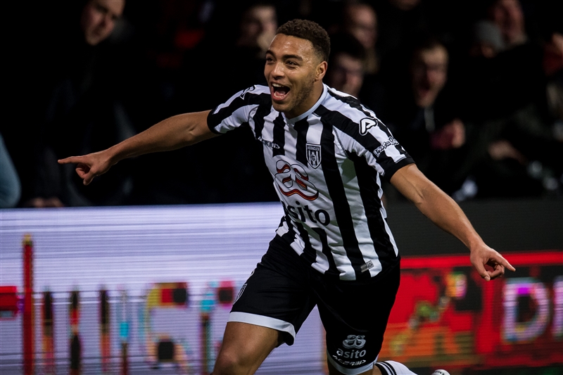 Cyriel Dessers of Heracles spreads his arms to celebrate scoring the winning goal against Ajax