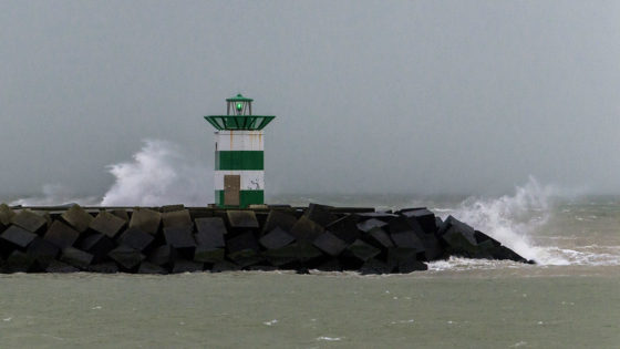 A lighthouse in Scheveningen over a storm-tossed sea