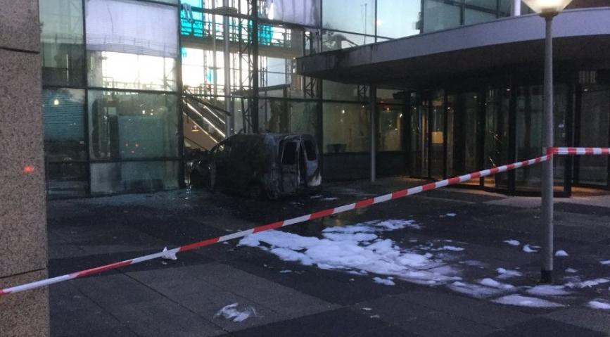 The burned-out Volkswagen Caddy van in the entrance to the Telegraaf building, cordoned off by red and white police tape.