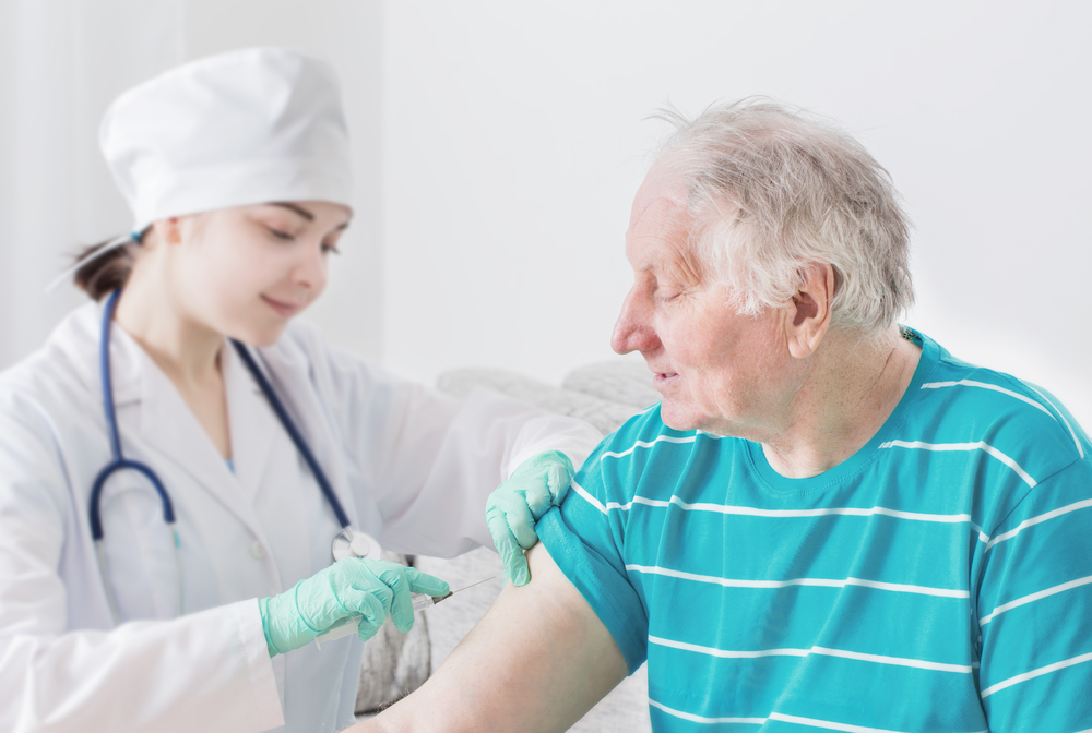 A nurse giving a vaccine to an elderly person